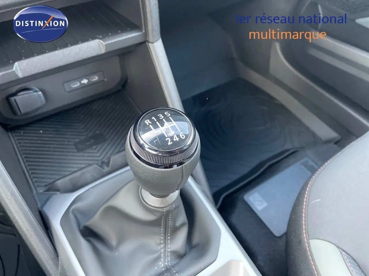 Le levier de vitesses manuel 6 rapports du Dacia Duster 2024, avec console centrale et partie des sièges visibles.