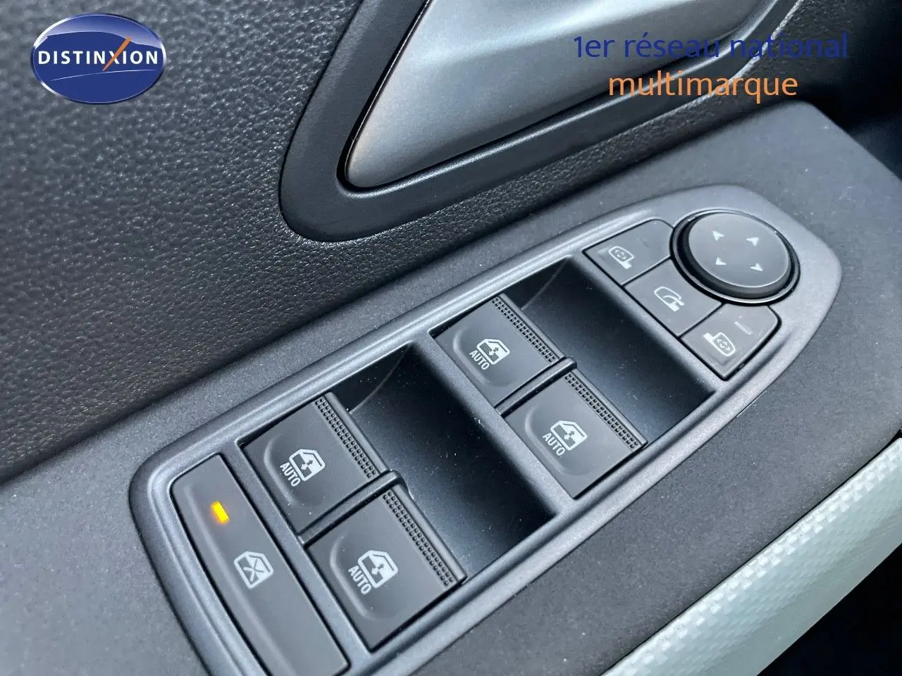 Gros plan sur les commandes des vitres électriques côté gauche d'un Dacia Duster noir métal 2024.