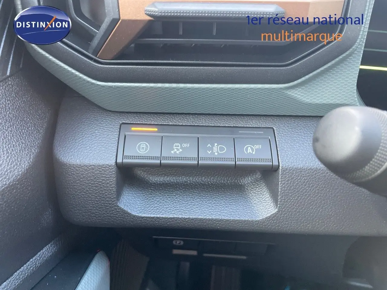 Gros plan sur les commandes de sécurité et d'éclairage du tableau de bord d'un Dacia Duster noir métal 2024.