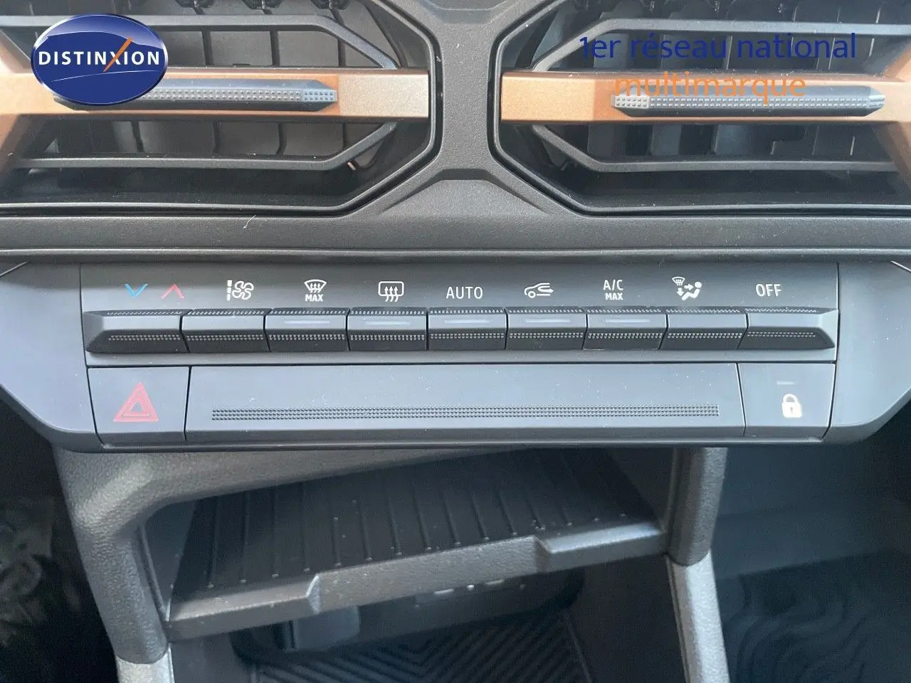 Vue rapprochée de la console centrale du Dacia Duster 2024 noir métal, mettant en valeur les commandes de climatisation et les aérateurs.