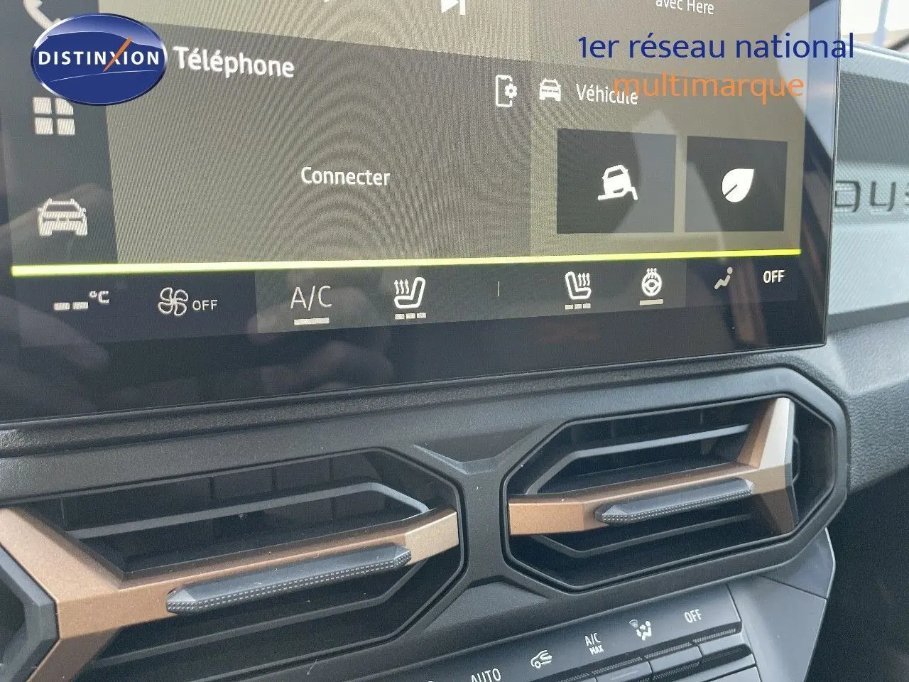 Vue rapprochée du tableau de bord du Dacia Duster 2024, mettant en valeur l'écran tactile et les aérateurs hexagonaux.
