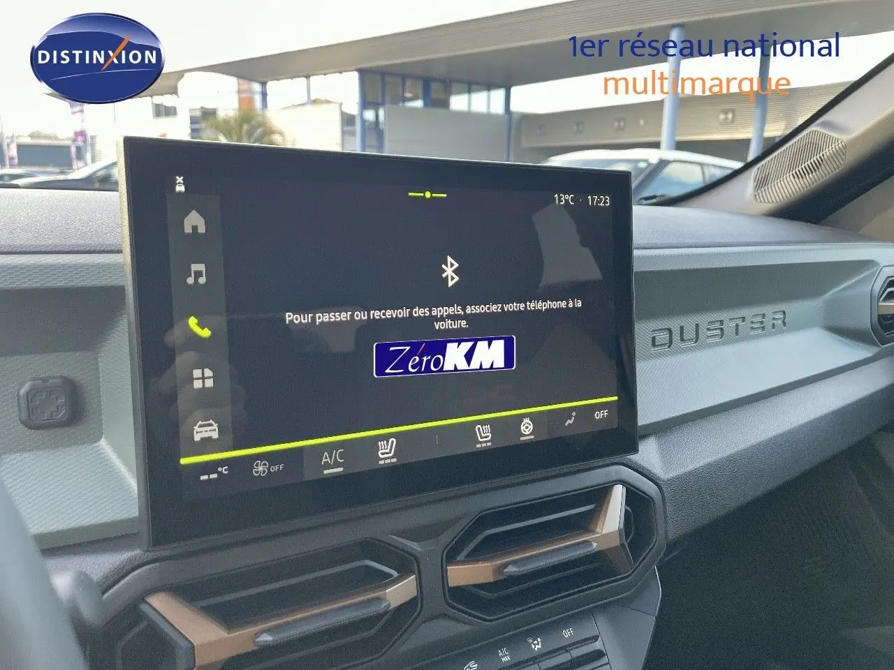 Vue intérieure du tableau de bord du Dacia Duster 2024 avec écran tactile et inscription DUSTER sur la planche de bord.