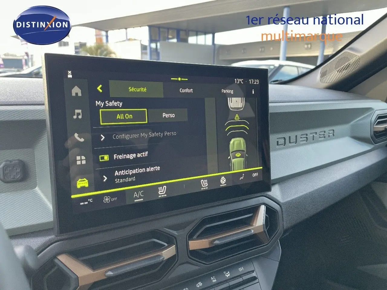 Vue intérieure du tableau de bord du Dacia Duster 2024 noir métal, avec écran tactile central et inscription DUSTER en relief.