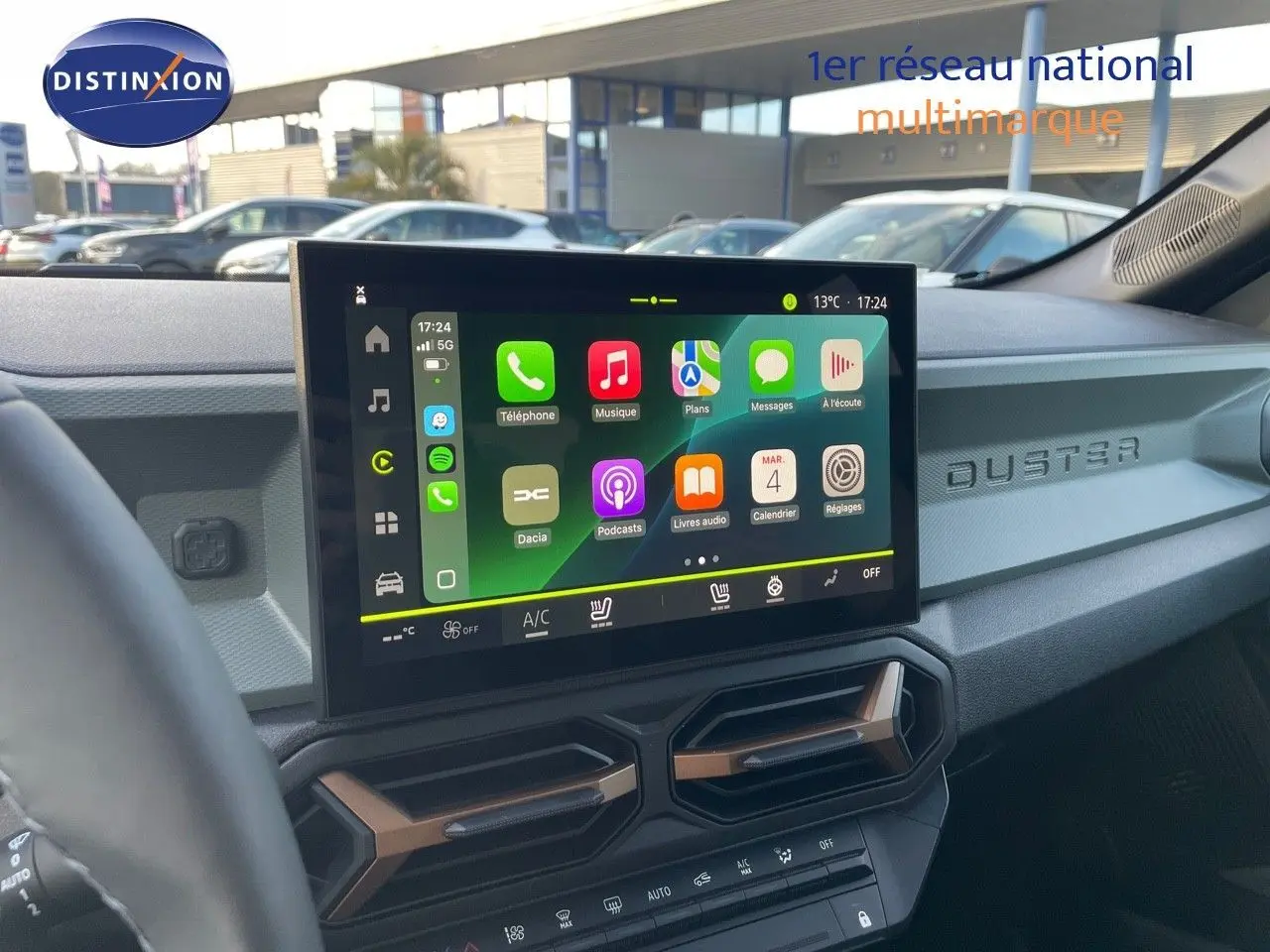 Vue intérieure du tableau de bord du Dacia Duster 2024 noir métal, avec écran tactile central et détails modernes.