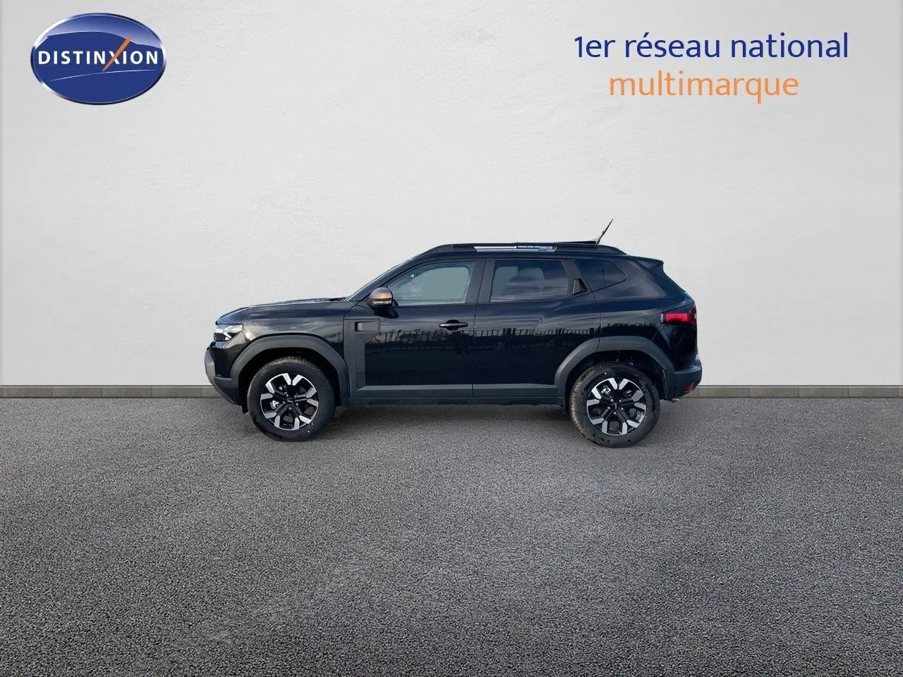 Profil droit du Dacia Duster 2024 noir métal, avec jantes bi-ton et rétroviseurs couleur bronze.