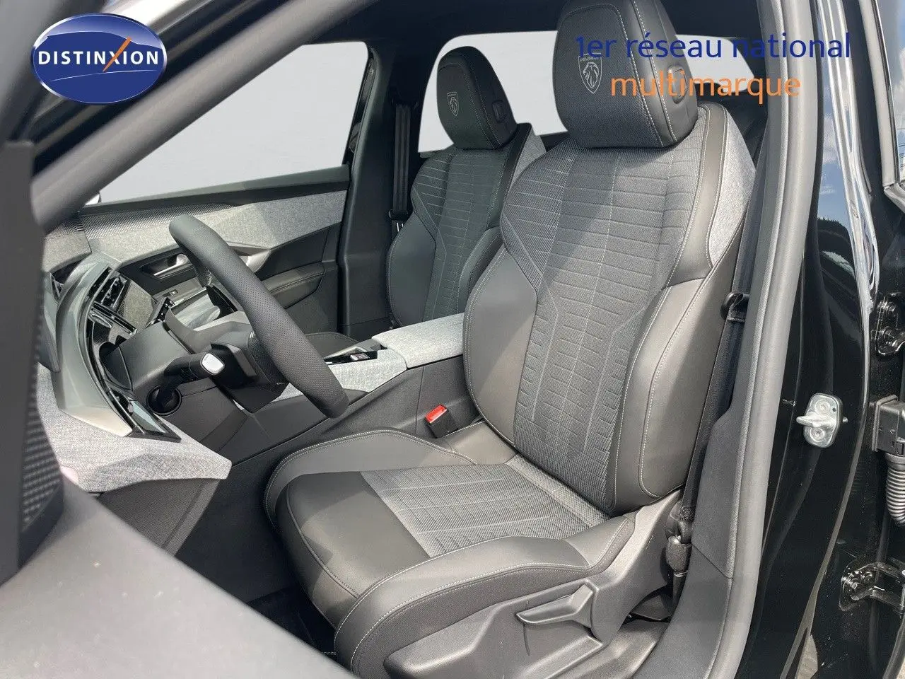 Vue intérieure côté conducteur du Peugeot 5008 noir perle métal, sièges en cuir et tissu gris avec logo Peugeot brodé.