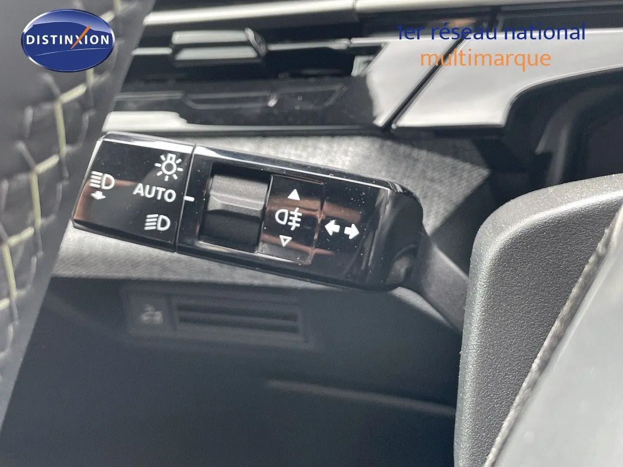 Gros plan sur le commodo des feux du Peugeot 5008 noir perle métal, montrant les commandes d'éclairage automatique et antibrouillard.