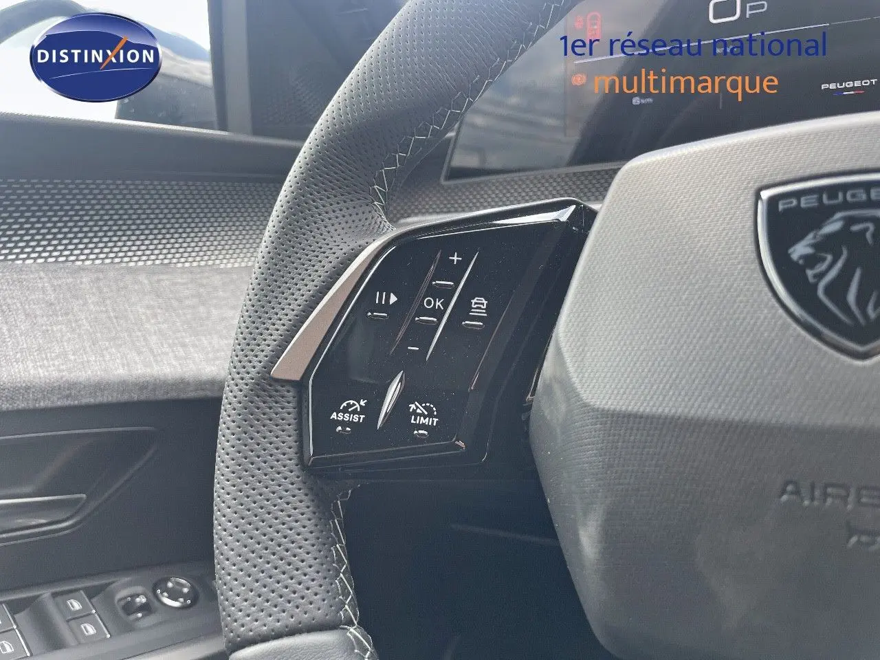 Gros plan sur le volant perforé et les commandes multifonctions du Peugeot 5008 Hybrid noir perle métal.