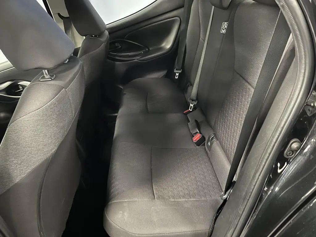 Vue côté droit des sièges arrière noirs en tissu de la Mazda2 2023 avec ceinture de sécurité et porte ouverte.