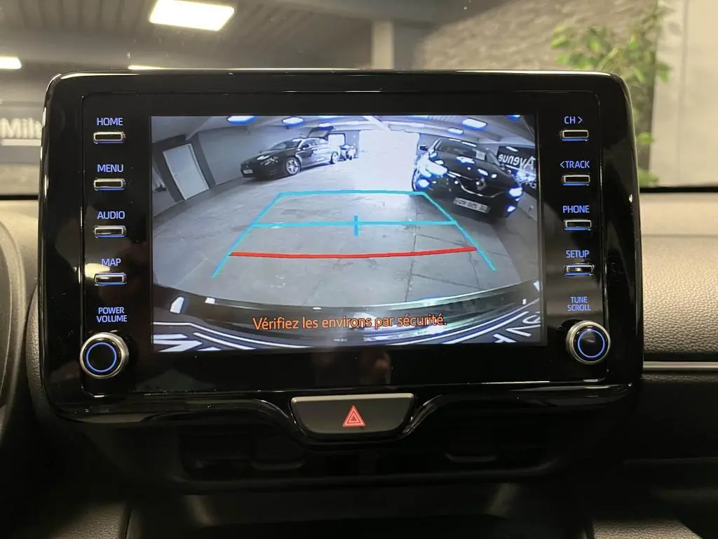 Écran de caméra de recul dans une Mazda2 noire 2023, montrant l'arrière en intérieur de garage.