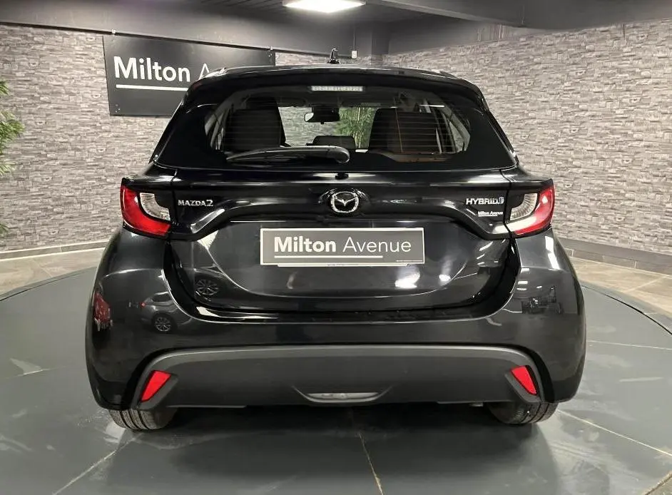 Vue arrière d'une Mazda2 noire hybride 2023 avec feux arrière LED et logo Mazda bien visibles.