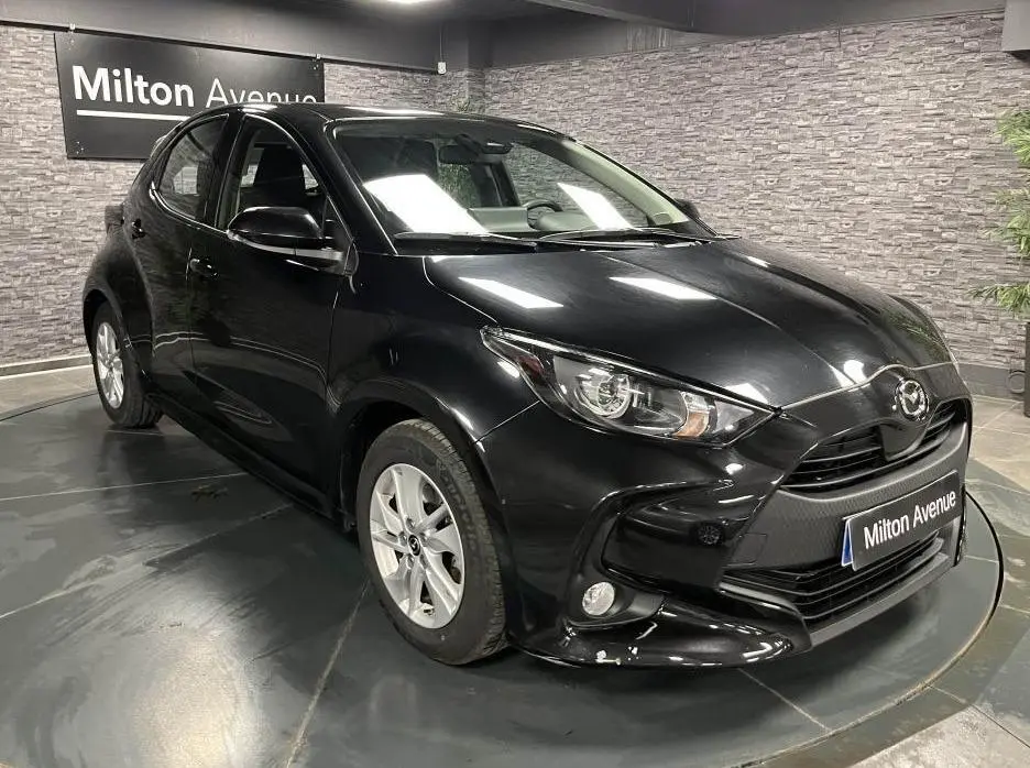 Vue 3/4 avant gauche de la Mazda2 noire 2023 avec calandre noire et jantes alliage argentées.