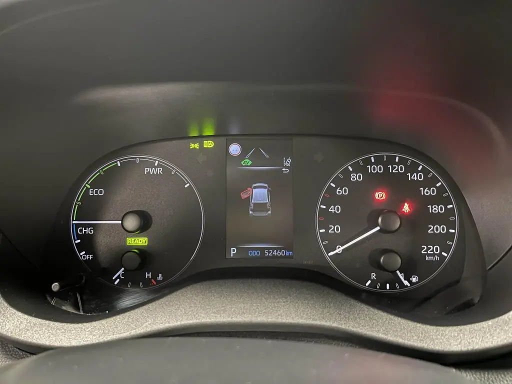 Tableau de bord de Mazda2 1.5 Hybrid 2023 montrant compteurs analogiques et écran central avec alertes et kilométrage.