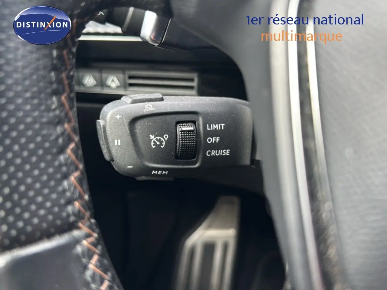 Gros plan sur la commande de régulateur de vitesse au volant d’une Peugeot 508 gris platinium, intérieur cuir noir.