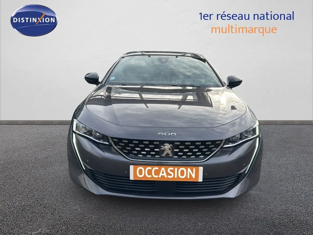 Vue frontale d'une Peugeot 508 gris platinium 2020 avec calandre distinctive et feux LED fins allumés.