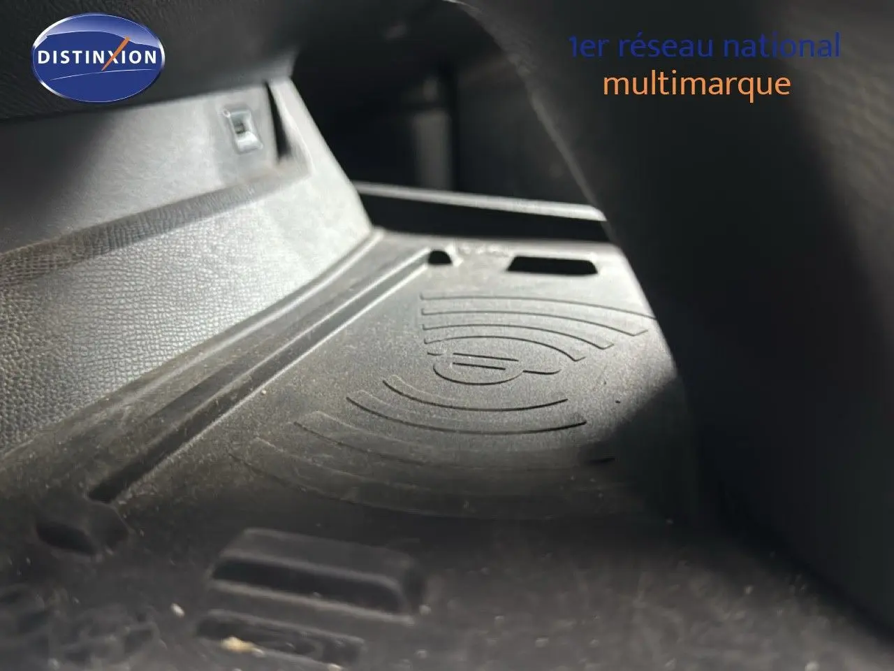 Gros plan sur le tapis de recharge sans fil dans l'habitacle d'une Peugeot 508 gris platinium.