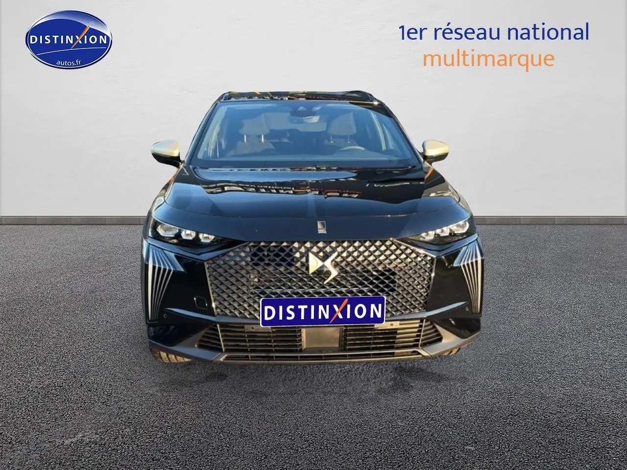 Vue avant d'un DS7 noir 2026 avec calandre distinctive et phares LED fins allumés sur fond neutre.