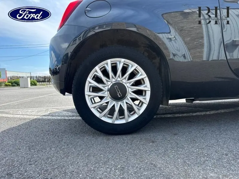 Gros plan sur la roue arrière droite d'une FIAT 500 Lounge 2018 en Crossover Black Métal avec jante alu 15 pouces.