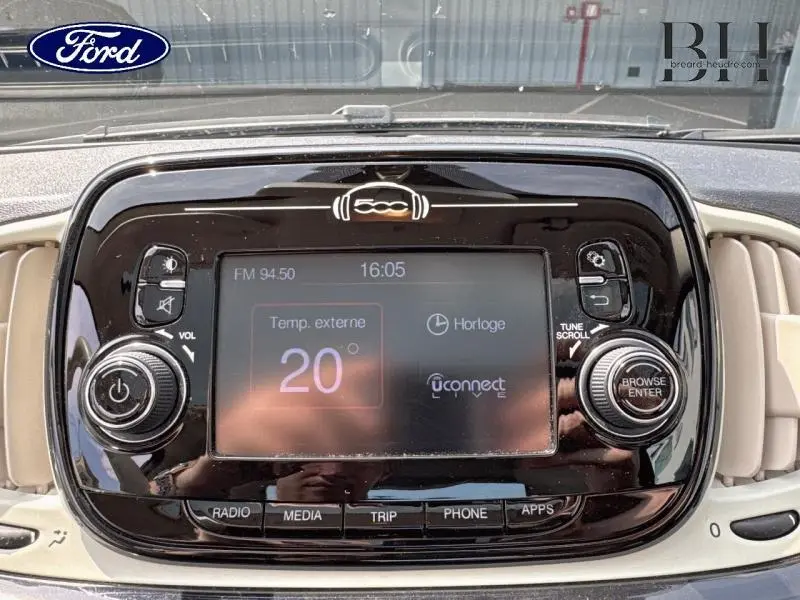 Vue rapprochée du tableau de bord noir brillant de la Fiat 500 Lounge 2018 avec écran tactile et commandes audio.