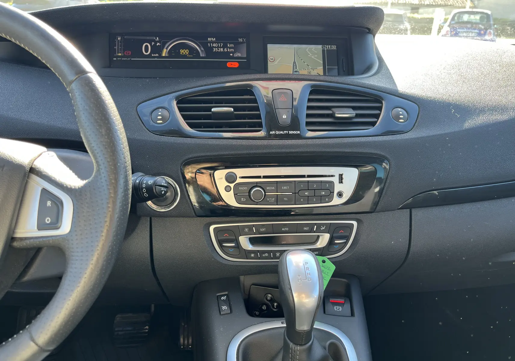 Intérieur du Renault Scenic III noir de 2012, vue du tableau de bord avec écran GPS et levier de boîte automatique.
