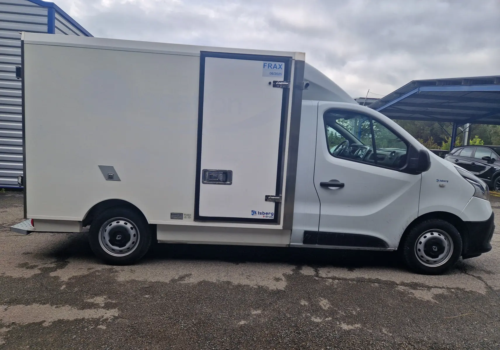 Vue latérale droite d'un utilitaire Renault Trafic blanc avec caisse frigorifique Iceberg et porte latérale isolée.