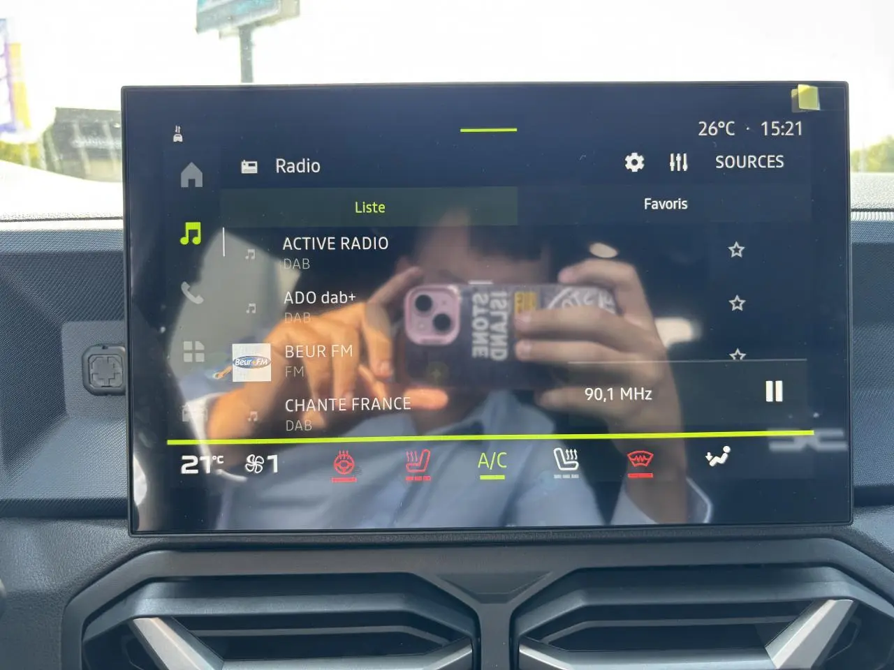 Écran tactile central du Dacia Duster 2025 affichant la radio numérique et commandes climatisation, intérieur moderne.
