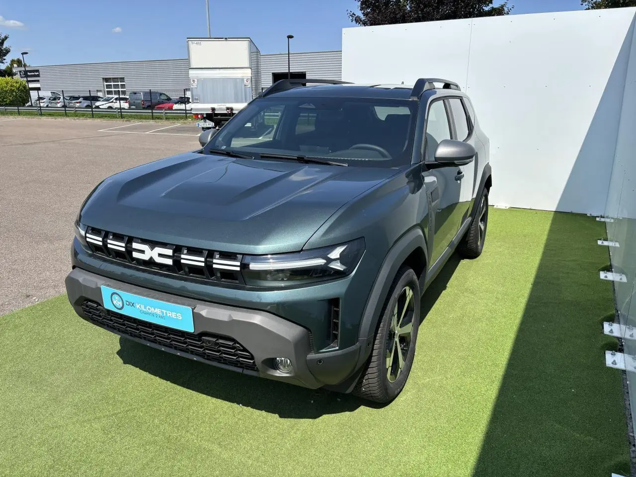 Dacia Duster III vert cèdre métal vu en 3/4 avant droit avec calandre distinctive et jantes alliage.