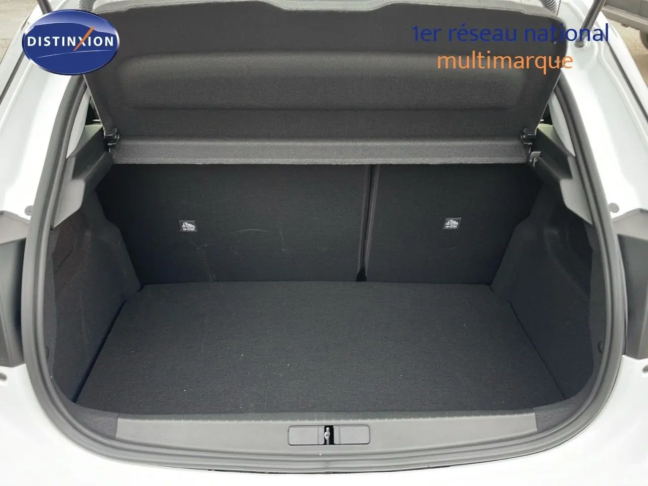 Coffre ouvert d'une Opel Corsa blanche Arctic 2025, vue arrière montrant l'espace de chargement vide et propre.