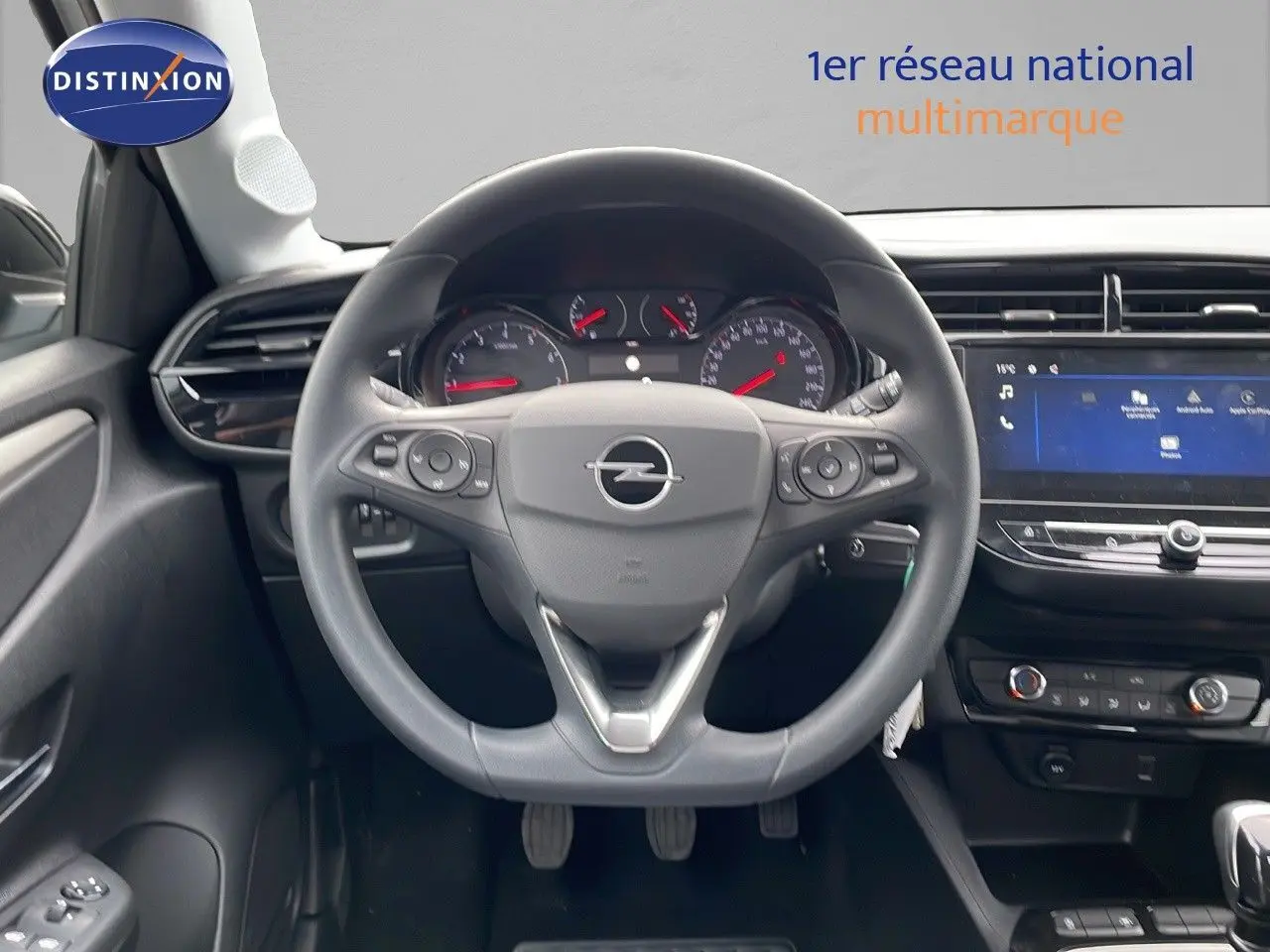 Vue intérieure centrée sur le volant Opel Corsa blanc arctique 2025 avec tableau de bord et écran tactile.