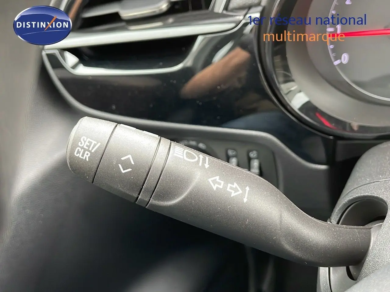 Gros plan sur la commande de clignotants à gauche du volant dans l'habitacle d'une Opel Corsa blanche 2025.