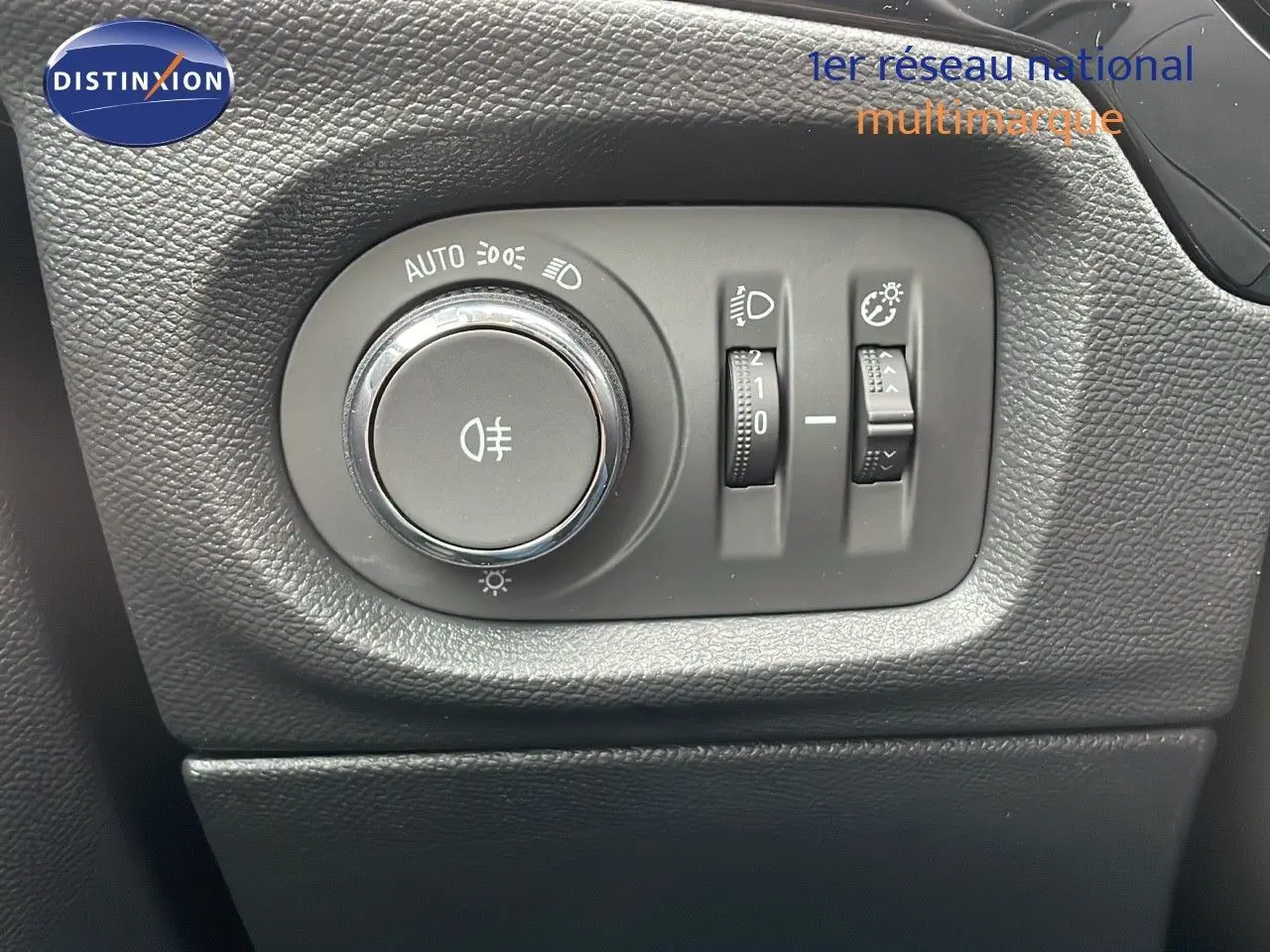 Gros plan sur les commandes d'éclairage noires à gauche du tableau de bord d'une Opel Corsa blanche Arctic 2025.