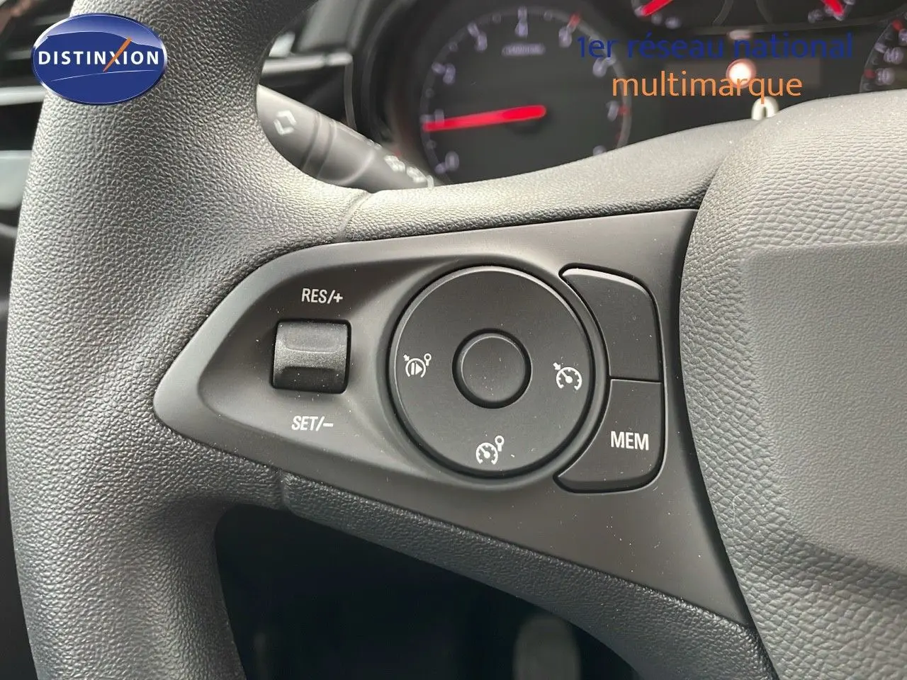 Gros plan sur les commandes de régulateur de vitesse au volant d'une Opel Corsa blanche Arctic 2025.