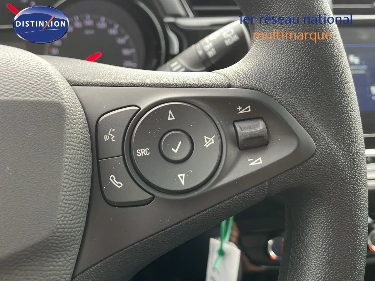 Gros plan sur les commandes multifonctions du volant en cuir noir d'une Opel Corsa blanche Arctic 2025.