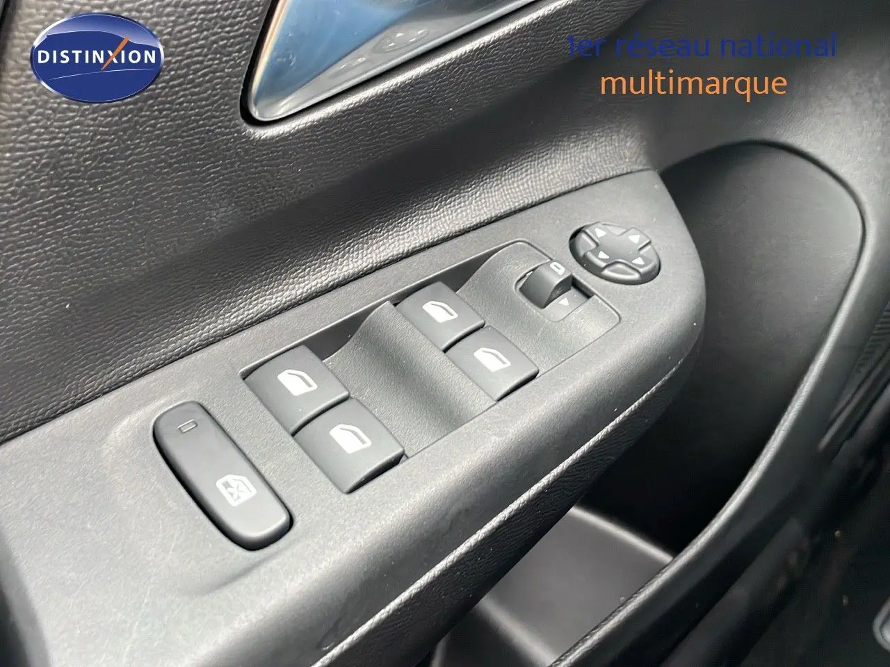 Gros plan sur les commandes des vitres électriques côté conducteur de l'Opel Corsa blanc arctique 2025.