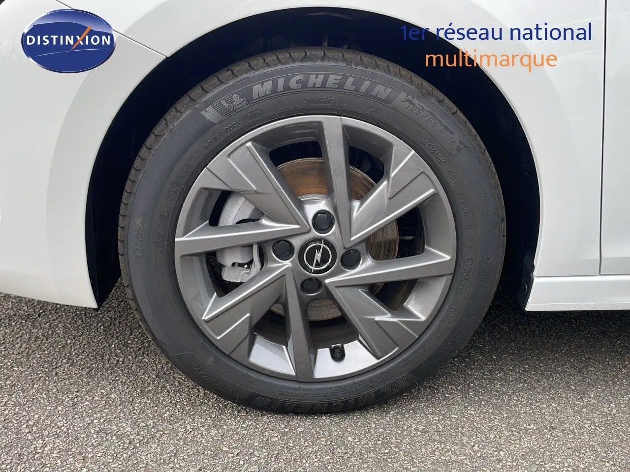 Gros plan sur la roue avant droite blanche d'une Opel Corsa 2025 avec jante alliage grise et pneu Michelin.