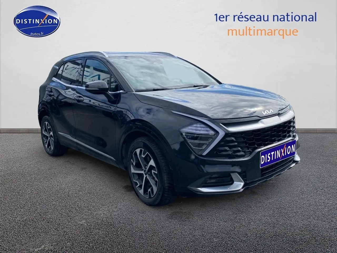 KIA Sportage noir en 3/4 avant droit avec calandre noire et jantes alu distinctives.