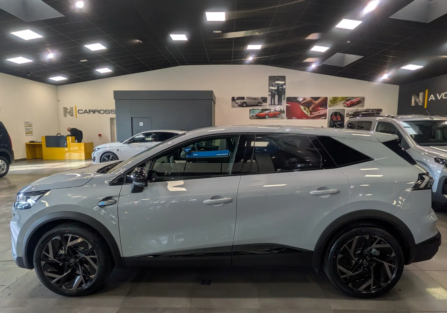 Vue de profil côté gauche du Renault SYMBIOZ E-TECH gris Rafale, avec jantes noires et détails noirs contrastants.