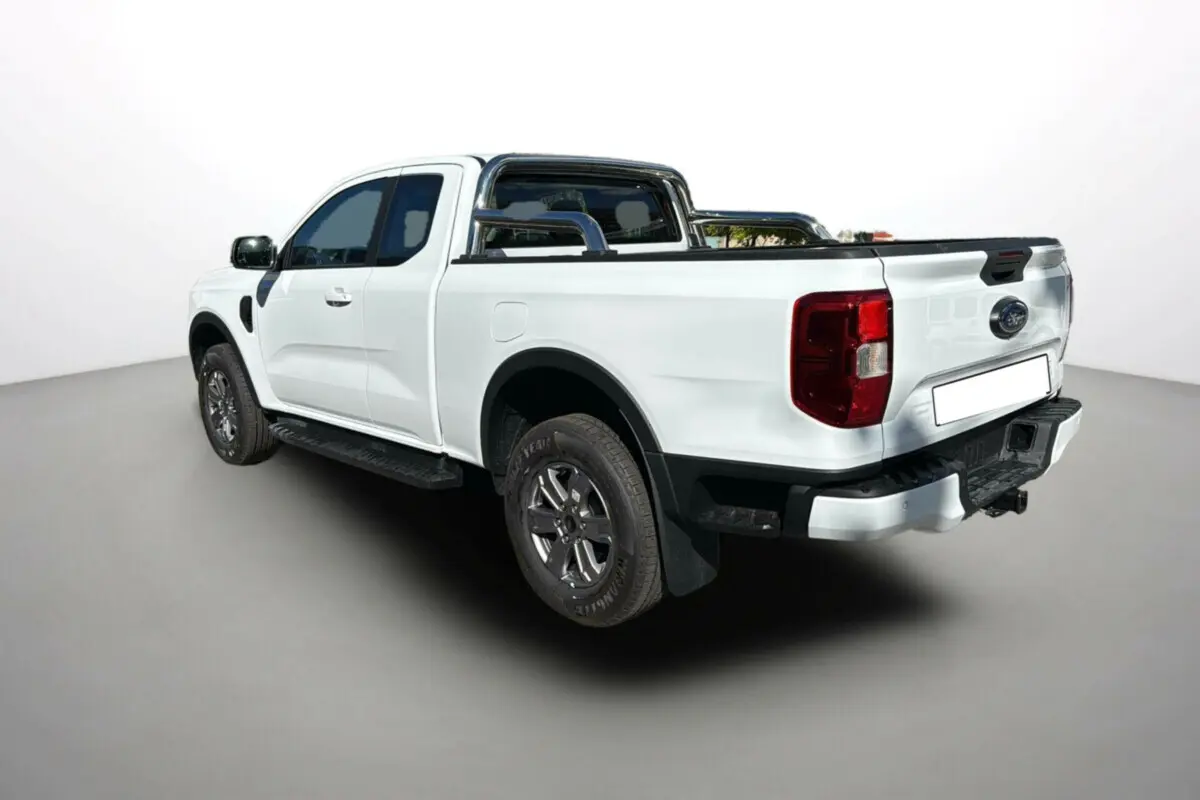 Ford Ranger blanc glacier en 3/4 arrière droit, avec arceaux inox et rideau coulissant sur la benne.