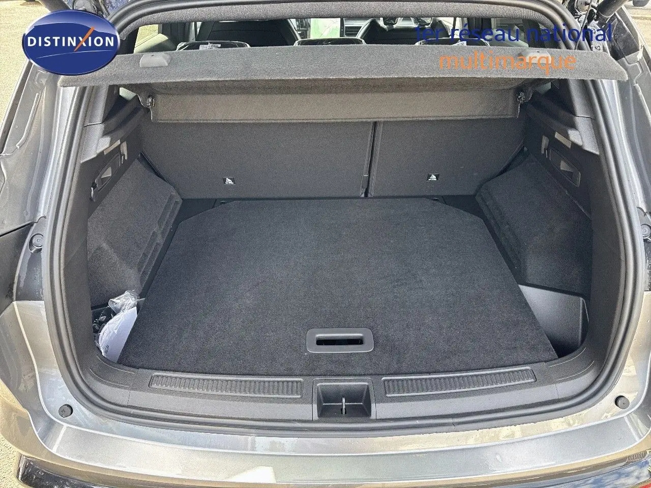 Coffre ouvert vu de l'arrière d'un Renault Austral gris schiste métal avec toit noir, montrant un espace de chargement propre.