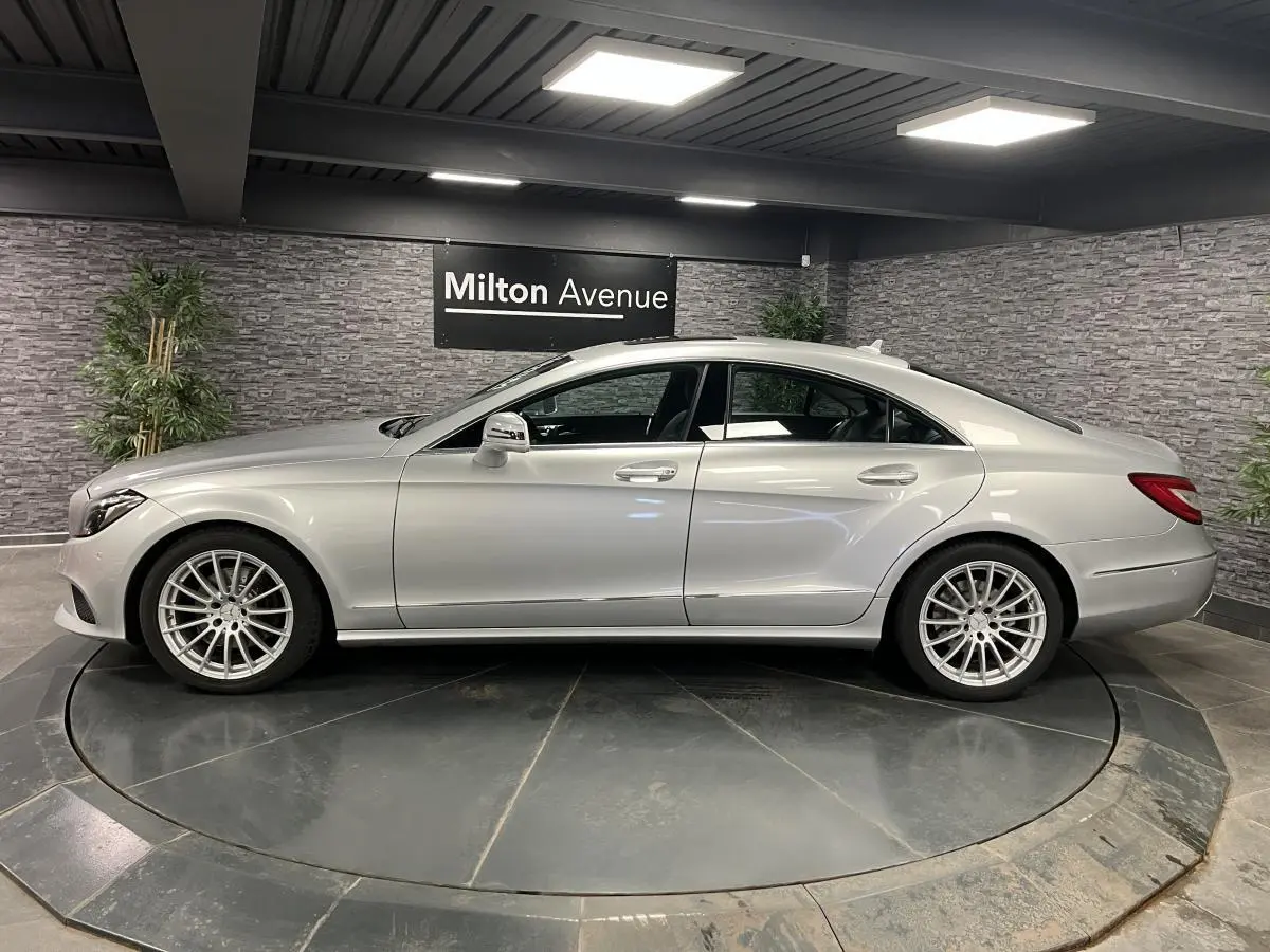 Profil droit d'une Mercedes Classe CLS 350 d gris métallisé avec jantes alliage multibranches en showroom.
