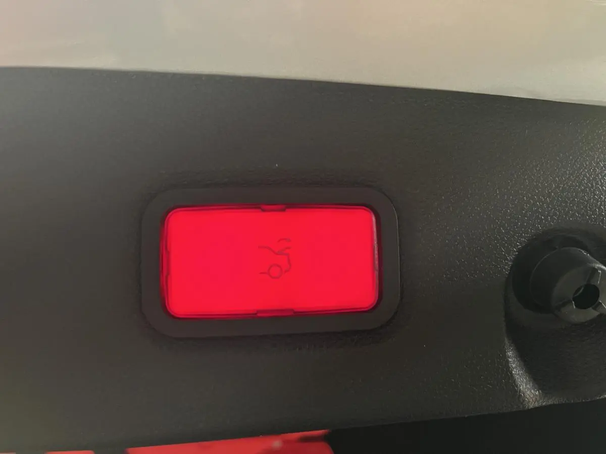 Bouton rouge d'ouverture électrique du hayon sur la garniture intérieure d'une Mercedes CLS 350 d gris