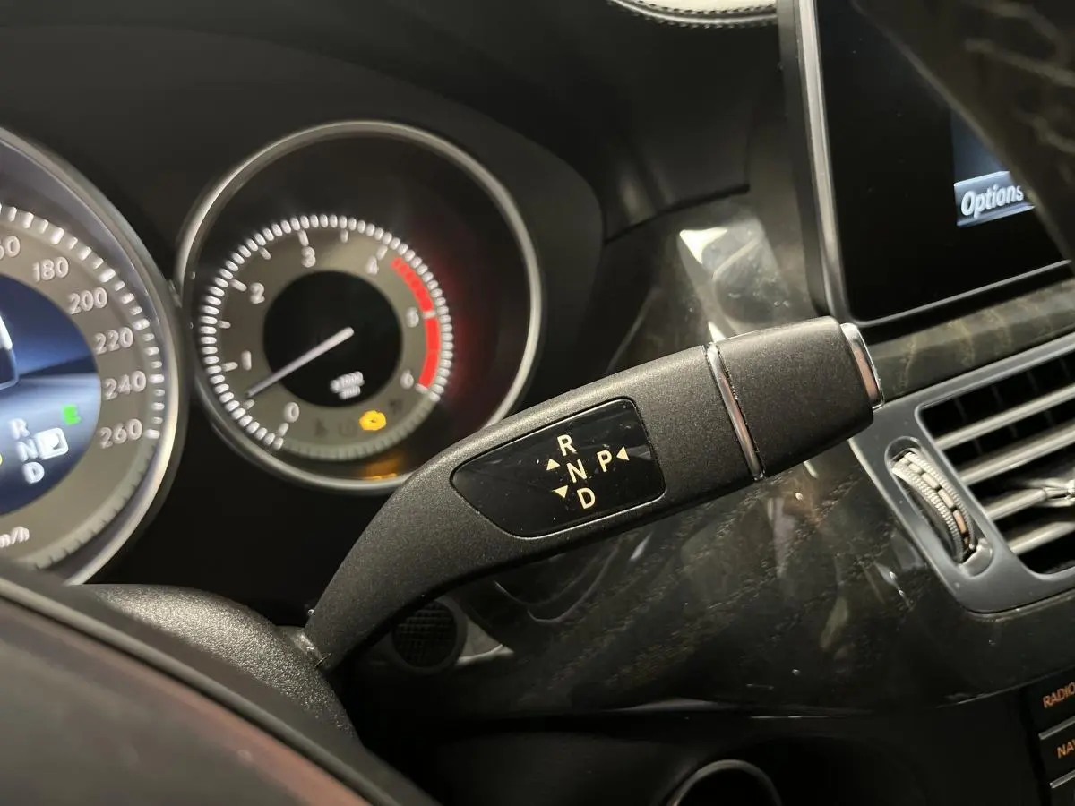 Gros plan sur le levier de boîte auto 9G-Tronic dans l'habitacle noir du Mercedes CLS 350 d gris de 2015.