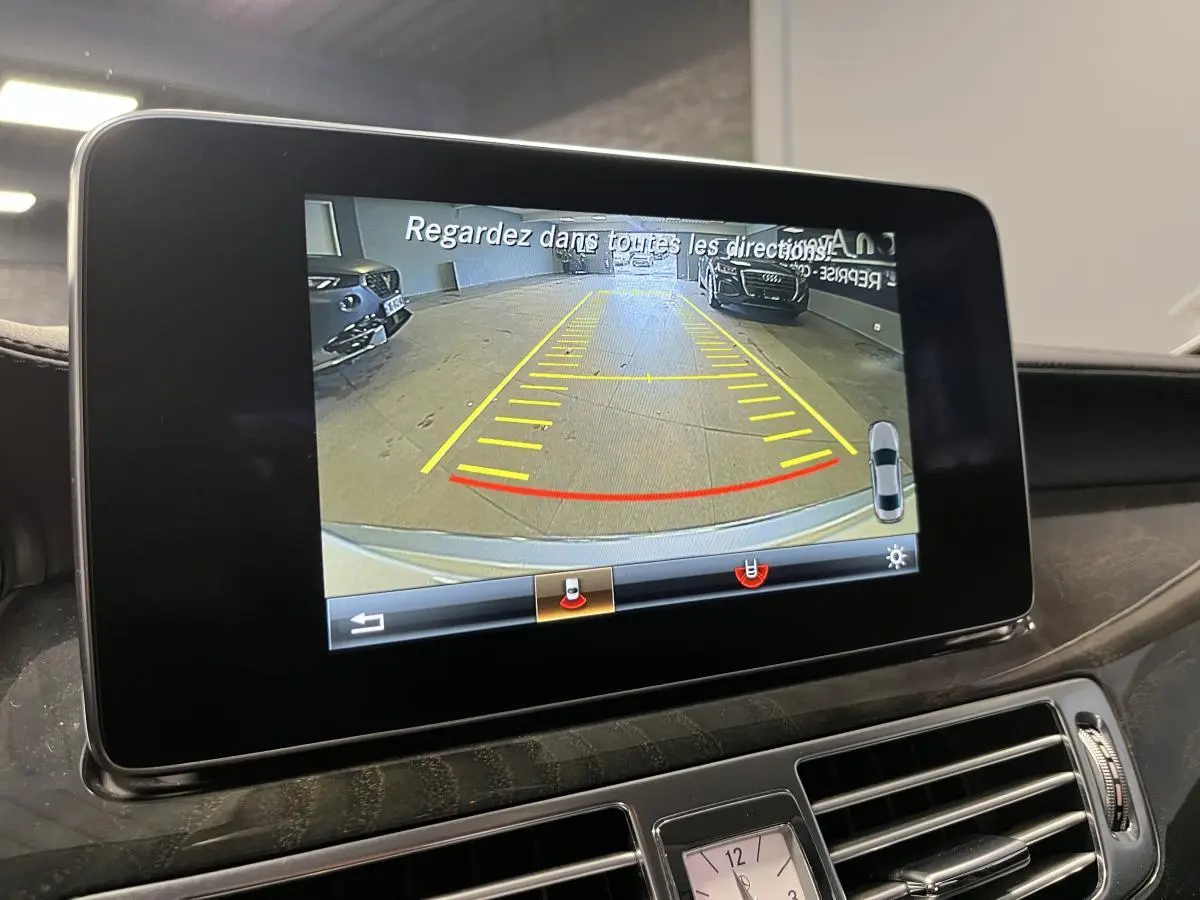 Écran central de la Mercedes CLS 350 d 2015 montrant la caméra de recul avec lignes de guidage en intérieur.