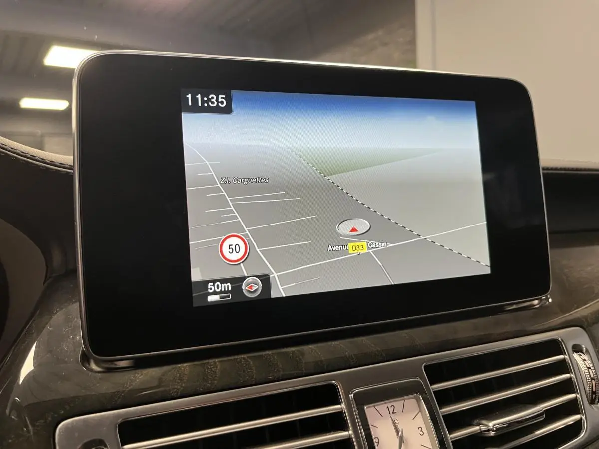 Écran de navigation Garmin MAP PILOT affichant une carte, intégré au tableau de bord en bois clair d'une Mercedes CLS 350 d gris.
