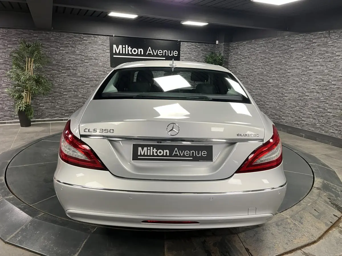 Vue arrière d'une Mercedes CLS 350 d gris clair avec feux arrière LED et logo Bluetec visible.
