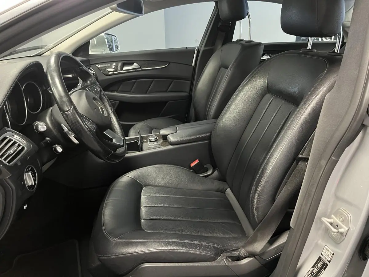 Intérieur noir cuir de la Mercedes Classe CLS 350 d 2015, vue côté conducteur avec volant multifonctions et console centrale.