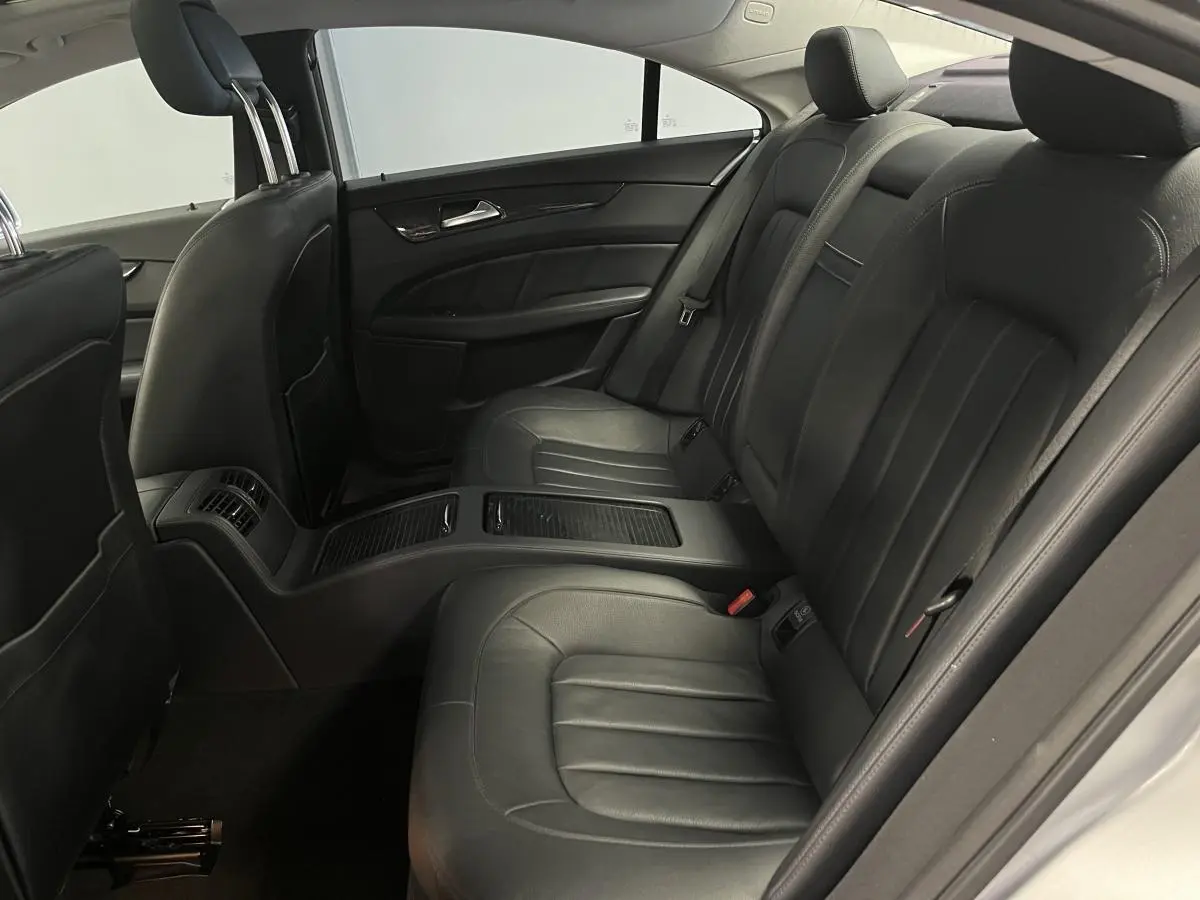 Vue intérieure des sièges arrière en cuir noir de la Mercedes CLS 350 d gris, avec accoudoir central et finitions élégantes.