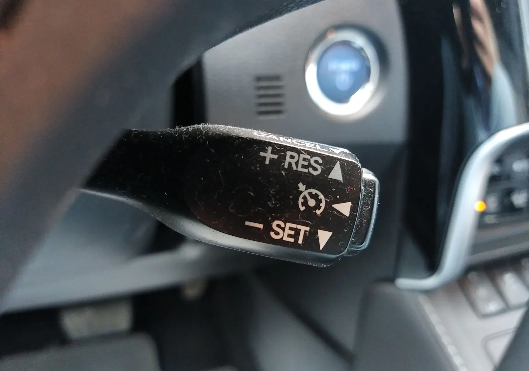 Le levier de régulateur de vitesse noir en gros plan dans l'habitacle d'une Toyota Auris blanche hybride de 2016.