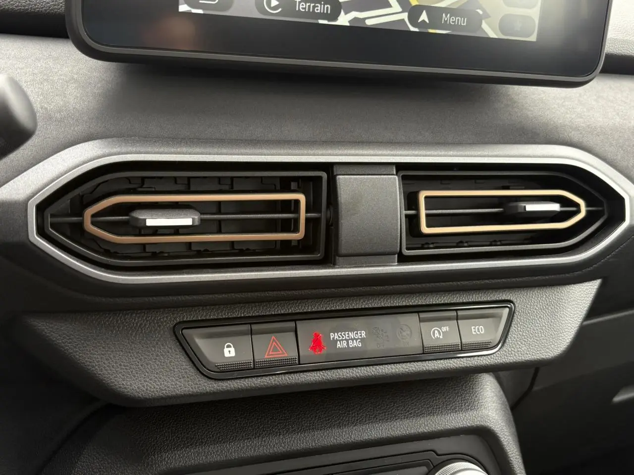 Gros plan sur les aérateurs centraux du tableau de bord de la Dacia Sandero Stepway 2025, avec détails beige Safari.