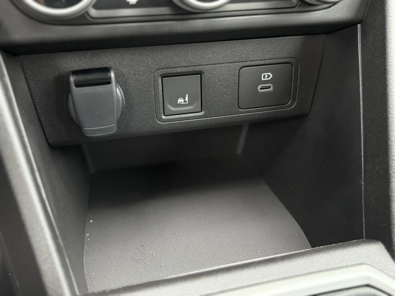 Gros plan sur la console centrale de la Dacia Sandero Stepway 2025, montrant les prises USB et le bouton d’aide au maintien.